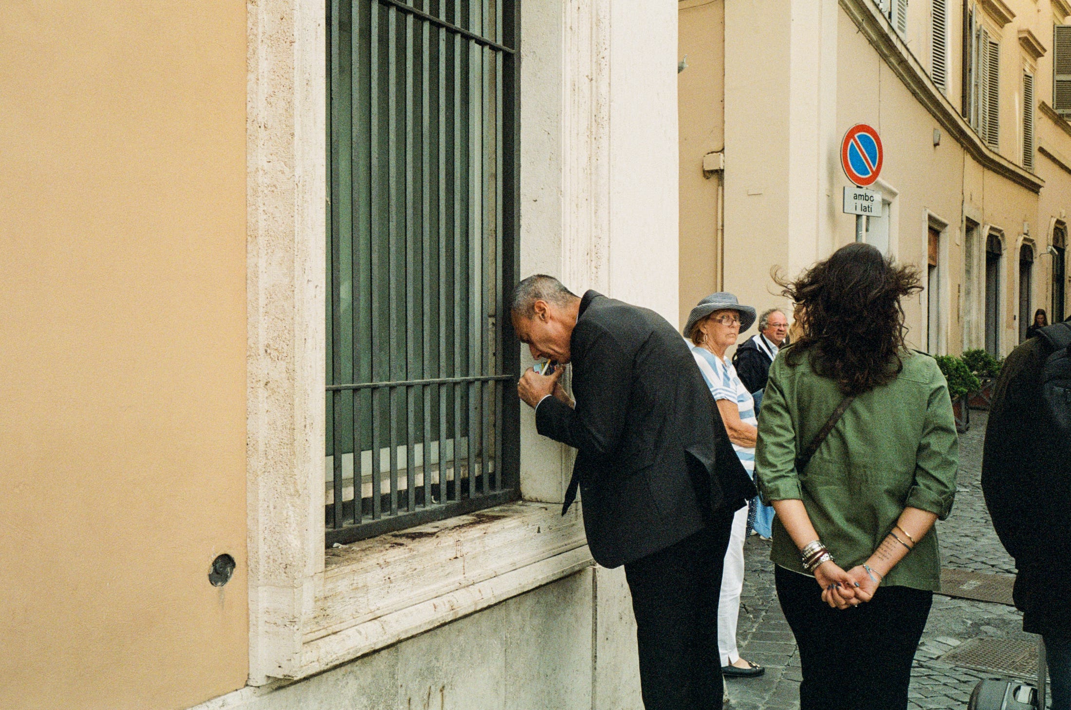 A man lights a cigarette against the wind. Rome 2022