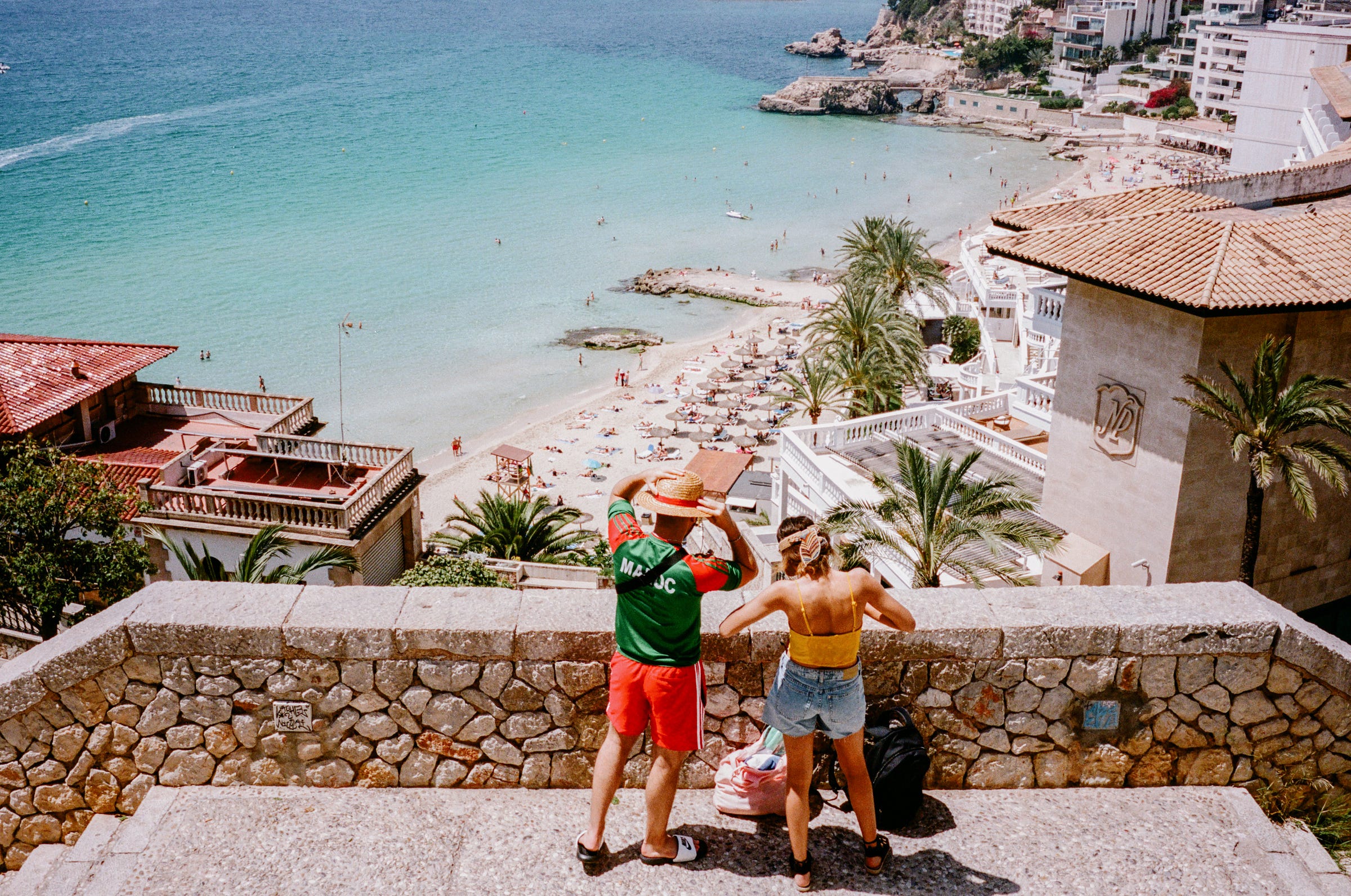 A super colourful couple takes in the view over the beach. Palma 2022