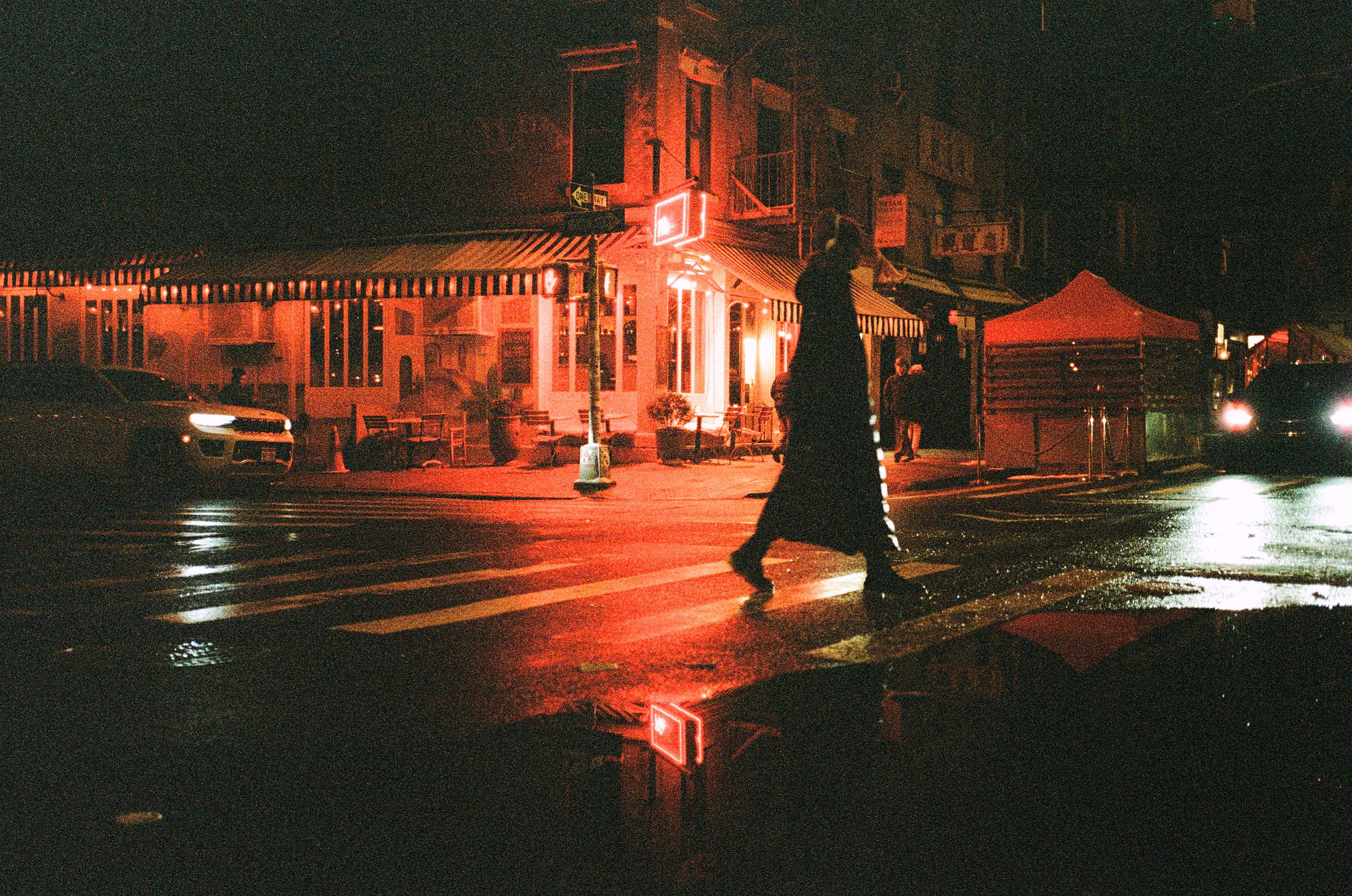A rainy night lights up the street in deep red hues. Jan 2024